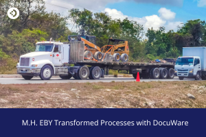 Flatbed truck transporting industrial equipment on a road, used to illustrate how M.H. EBY transformed processes with DocuWare.