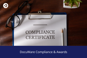 Clipboard with a document titled 'Compliance Certificate' resting on a desk beside eyeglasses and a pencil, with the text 'DocuWare Compliance & Awards' below.