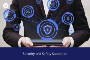 Person holding a tablet with a glowing digital shield icon and multiple security-related symbols connected around it, with the text 'Security and Safety Standards' below.
