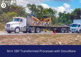 Flatbed truck transporting industrial equipment on a road, used to illustrate how M.H. EBY transformed processes with DocuWare.